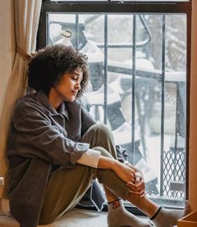 Black woman sitting by a window