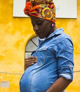 Black pregnant woman holding her belly