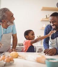 father, grandfather, and child baking together in a kitchen