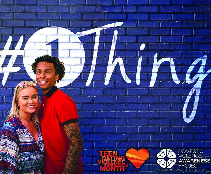 teen couple in front of blue brick wall with #1Thing logo