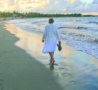 older woman walking on the beach